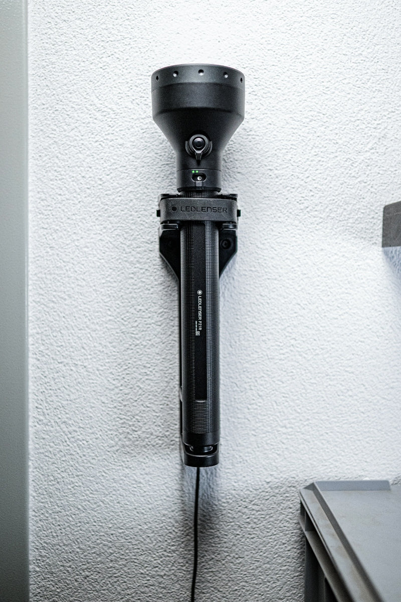 Ledlenser P21R Torch mounted upright on wall bracket; black high‑output rechargeable searchlight style