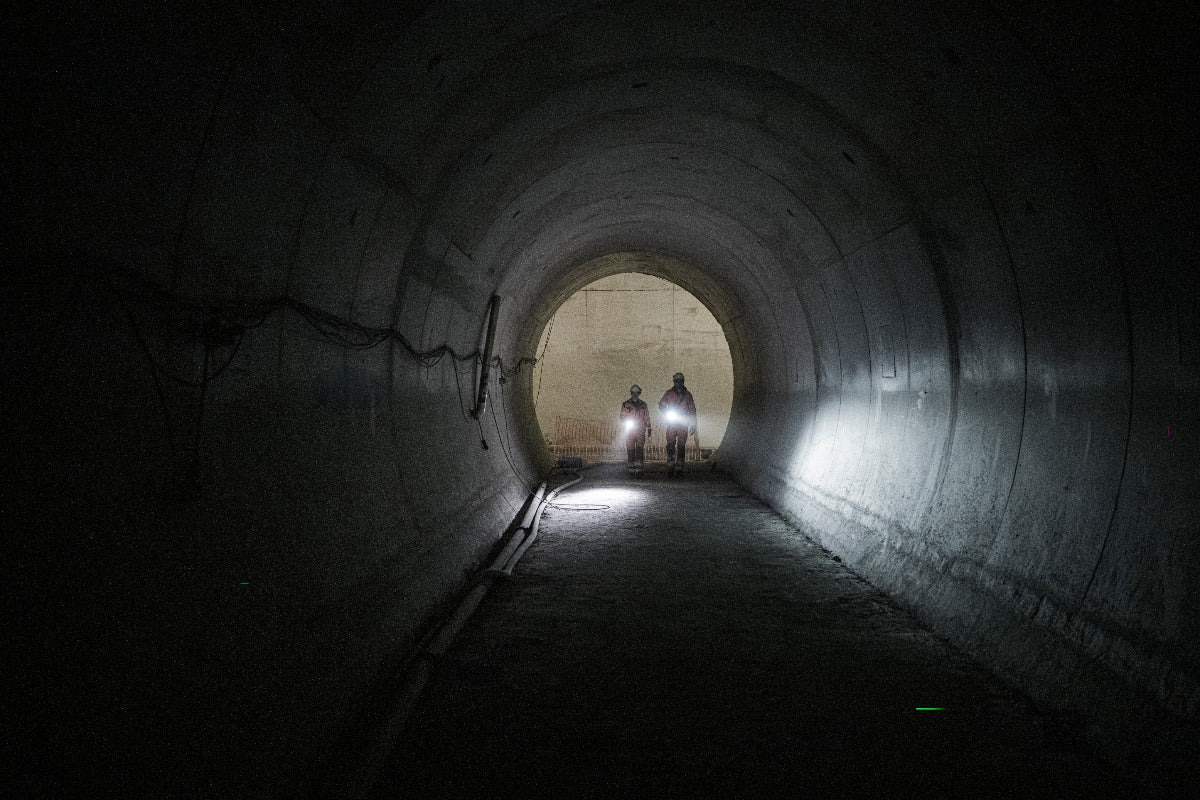 P21R Torch two workers in a dark tunnel with bright Ledlenser headlamps at the tunnel entrance