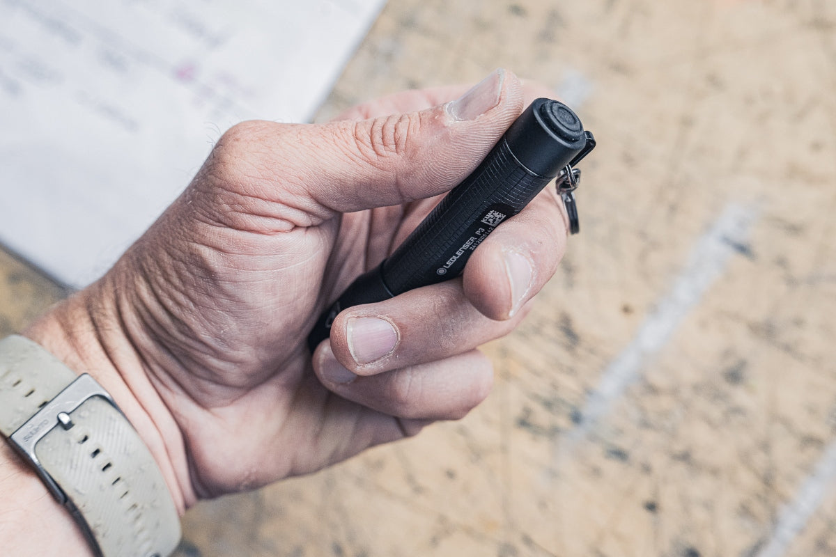 P3 Torch held in a hand compact black Ledlenser pocket flashlight with keyring attachment