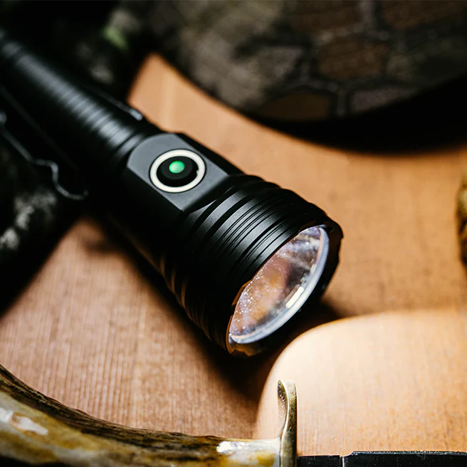Ledlenser TFX Propus 3500 Torch angled view showing black body with front lens and green power indicator on a wooden surface