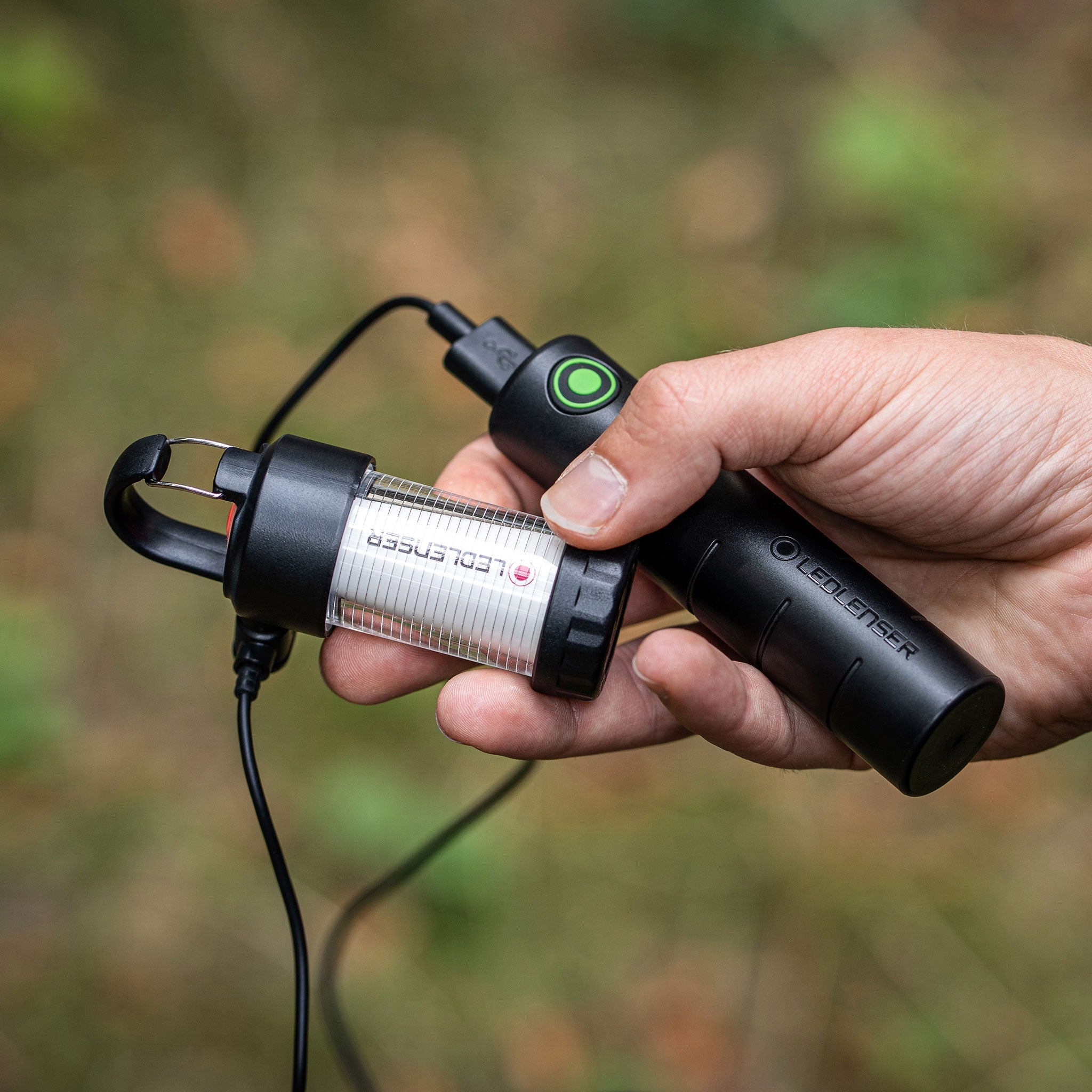 Ledlenser Flex3 Powerbank held in hand showing black controller with green button and silver cylindrical battery module connected by cable