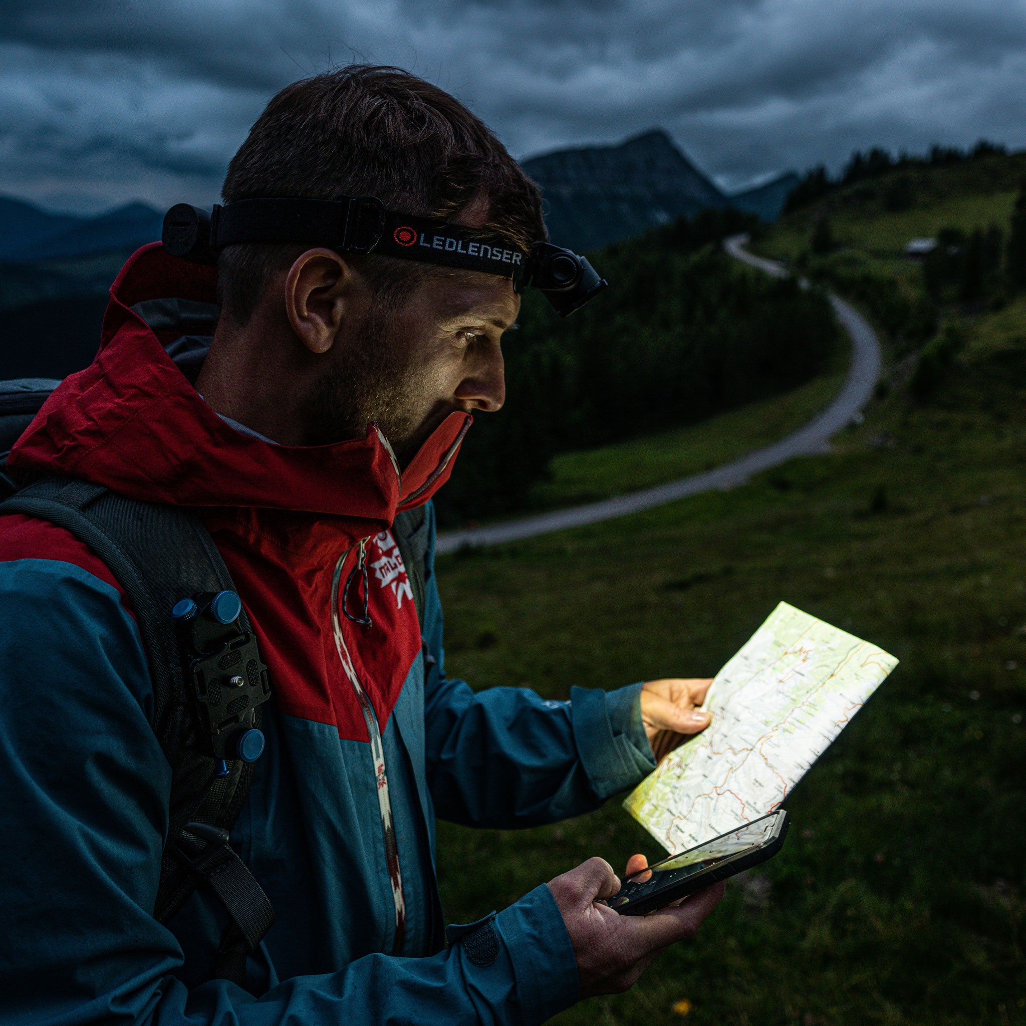 H7R Core Headlamp worn by a hiker reading a map outdoors at dusk with a backpack; headlamp mounted on a black headband branded Ledlenser