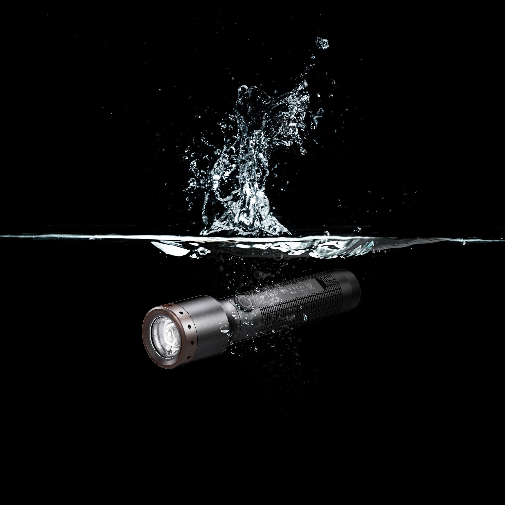 Ledlenser P5R Core Torch submerged in water with splash showing a compact rechargeable flashlight design in a dark background