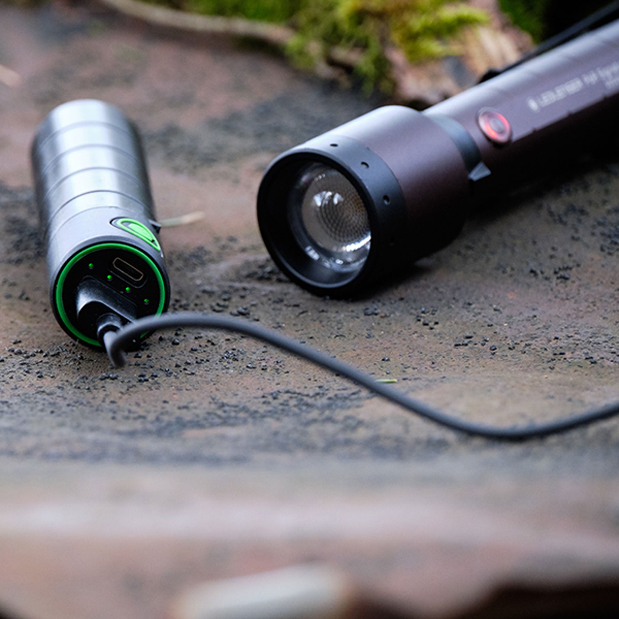 Ledlenser P6R Signature Torch with detachable head and charging tail cap on a rough surface showing green ring USB C port and the lens assembly