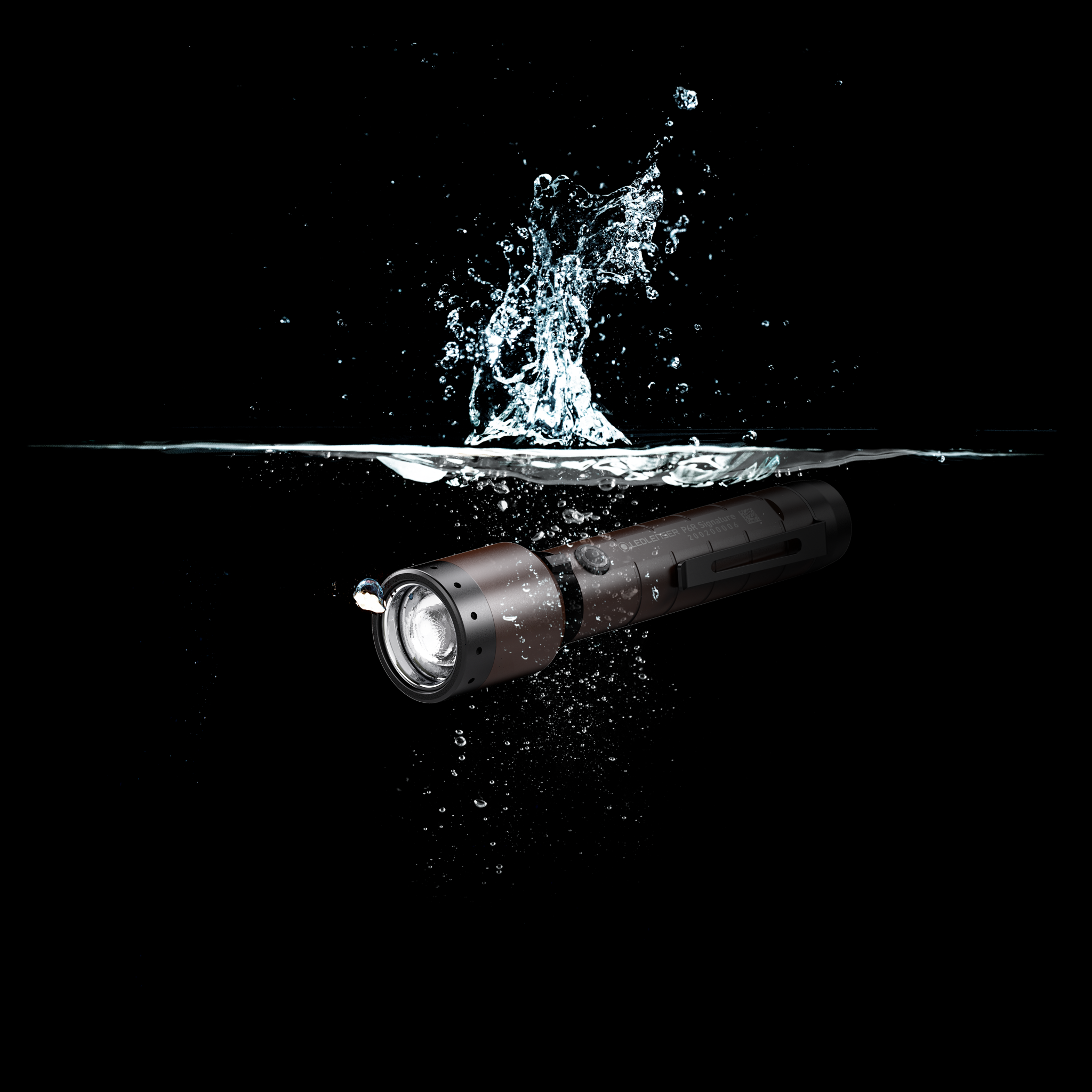 Ledlenser P6R Signature Torch underwater shot showing brown metal body with splash handheld rechargeable flashlight