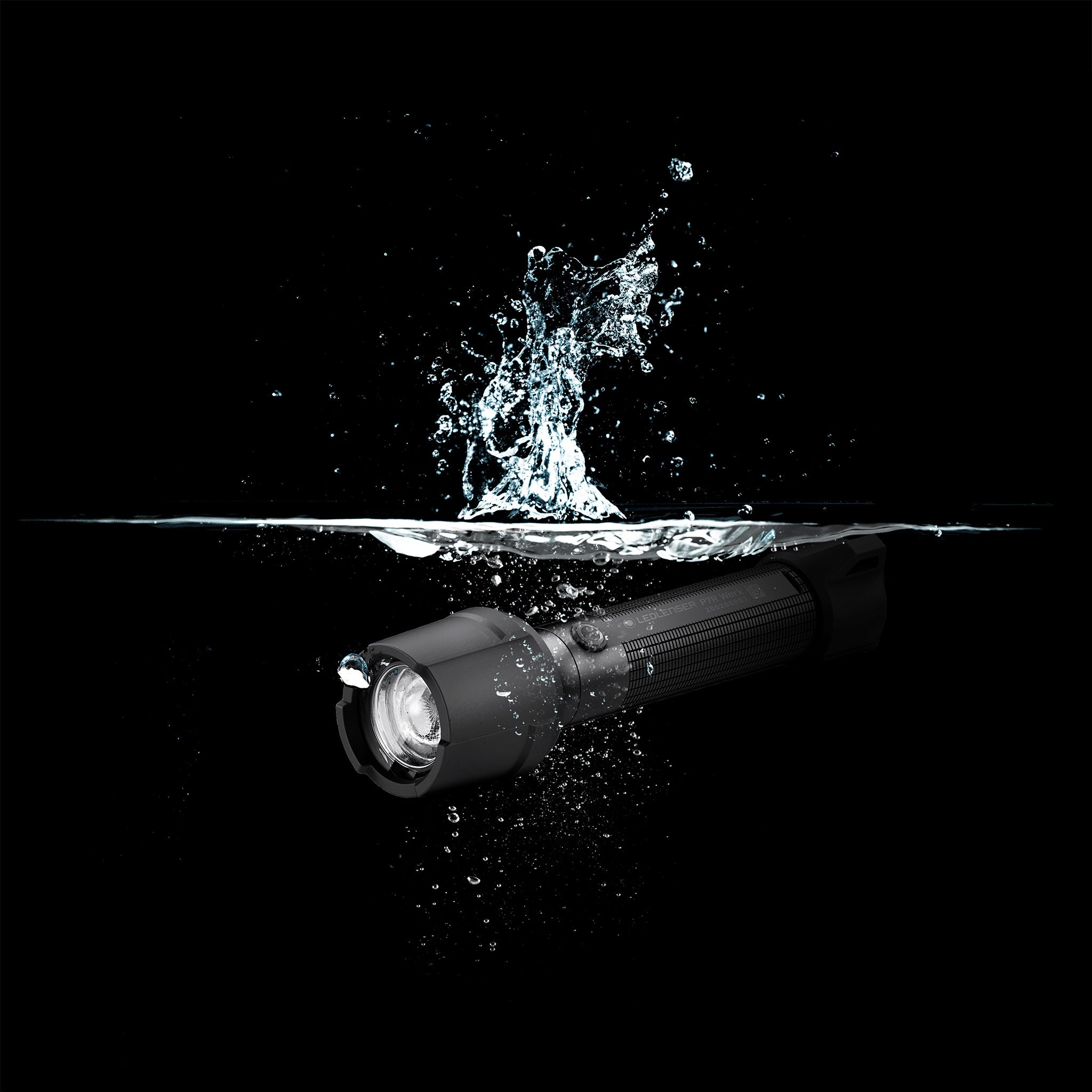 Ledlenser P7R Work Torch submerged in water with splash against a black background a rugged handheld torch