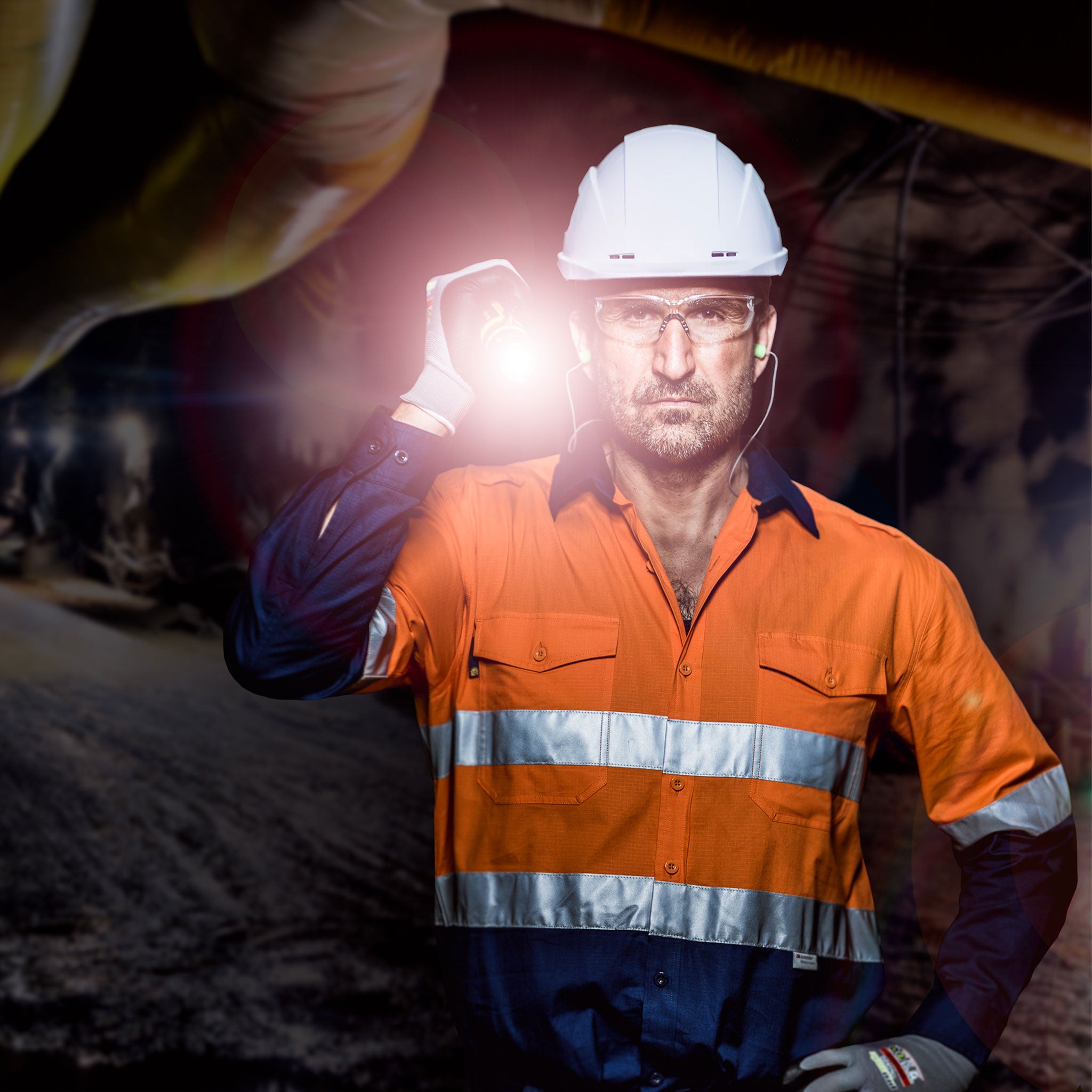 iL7R Torch being held by a safety professional wearing a white hard hat and orange high‑visibility jacket