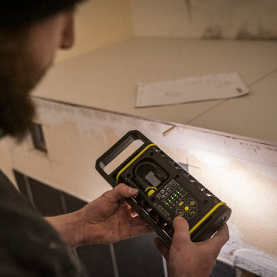 AF4R Work Floodlight being held by a technician showing its black body with yellow accents and control panel