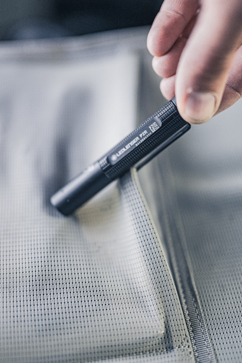 Ledlenser P2R Torch held in a hand close up of the black textured body and model label on the side