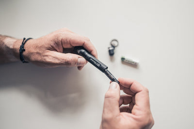P3R Torch being assembled by hands with small components on a light surface showing Ledlenser’s compact rechargeable torch
