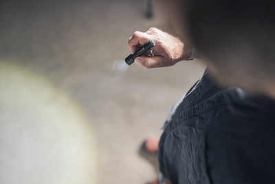 Ledlenser P3R Torch held in a right‑hand grip outdoors emitting a narrow beam from the compact black flashlight