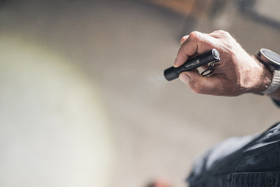 Ledlenser P3 Torch held in a right hand with keyring attachment a compact black flashlight shown in use