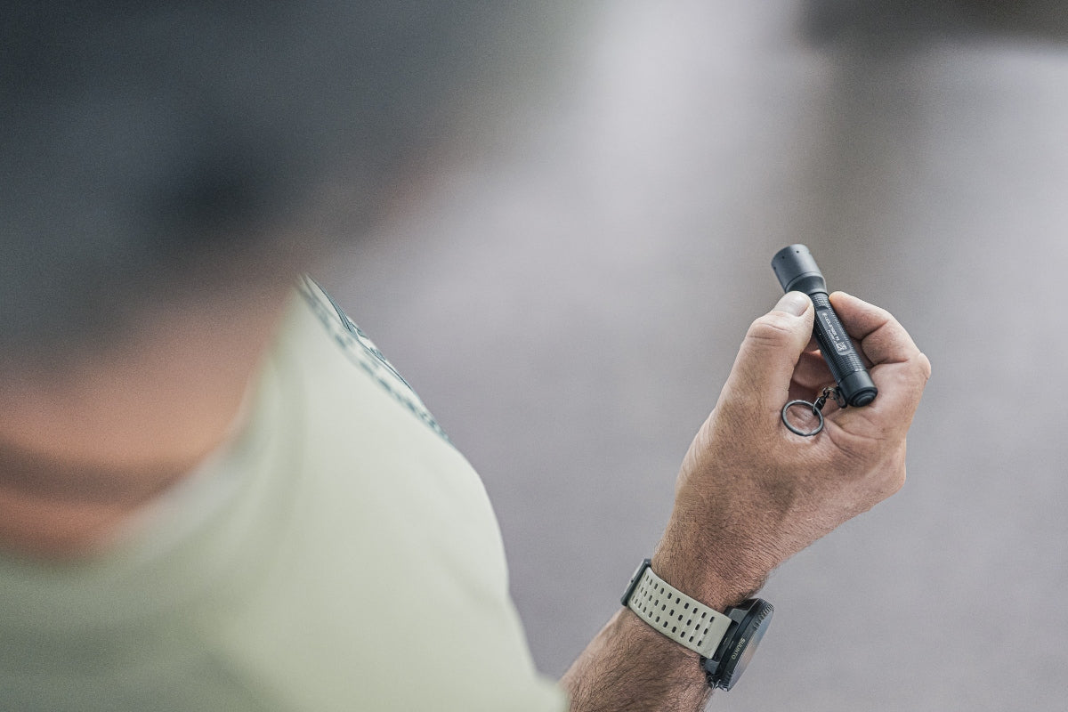 Ledlenser P3 Torch held in hand a compact key flashlight with a key ring grey black finish wearer’s wristwatch visible