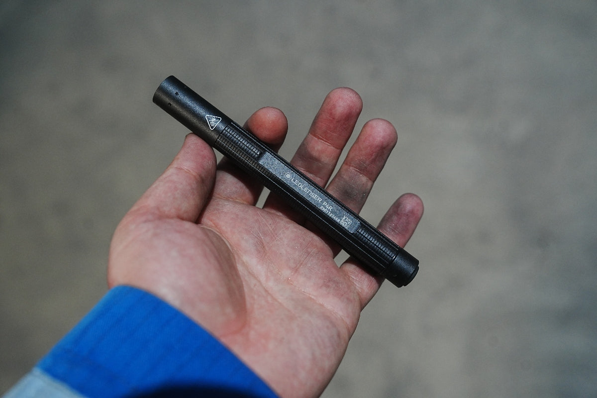 Ledlenser P4R Torch in black held in a hand; compact rechargeable pen style flashlight with textured grip