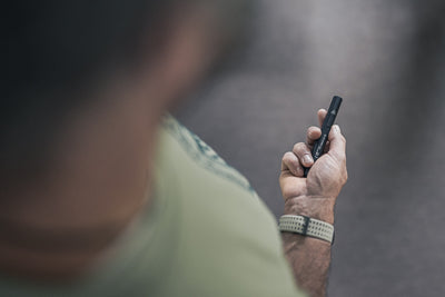 P4R Torch held in a hand compact black rechargeable torch shown in side grip with visible textured body and pocket clip