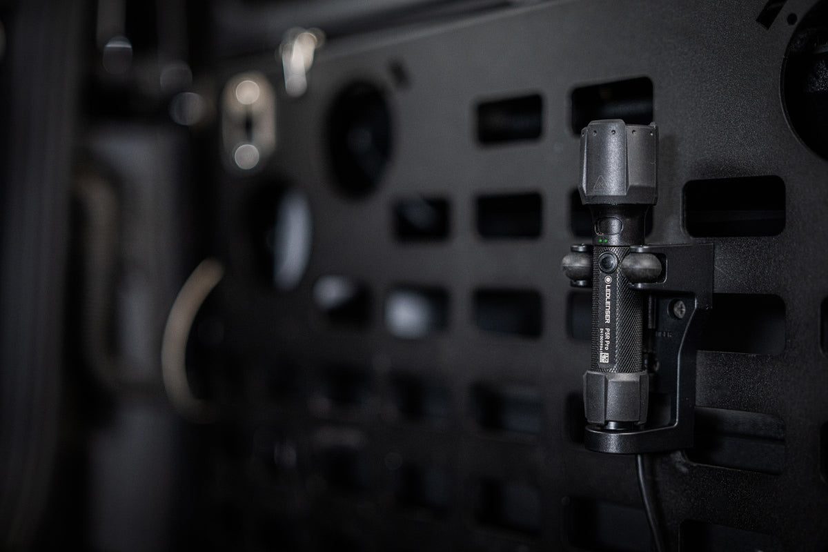 Ledlenser P5R Pro Torch mounted on a clamp bracket attached to a dark perforated panel in an industrial setting