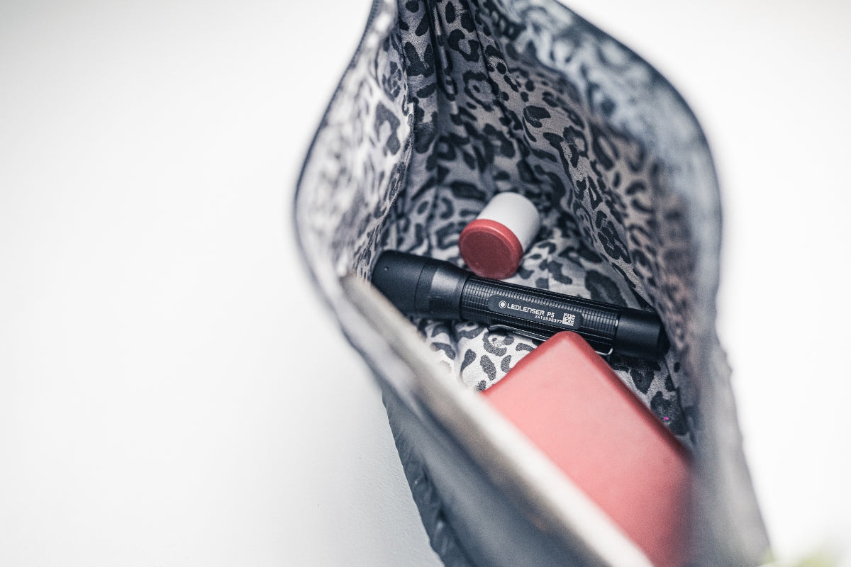 Ledlenser P5 Torch inside a patterned fabric bag with a red capped white container visible