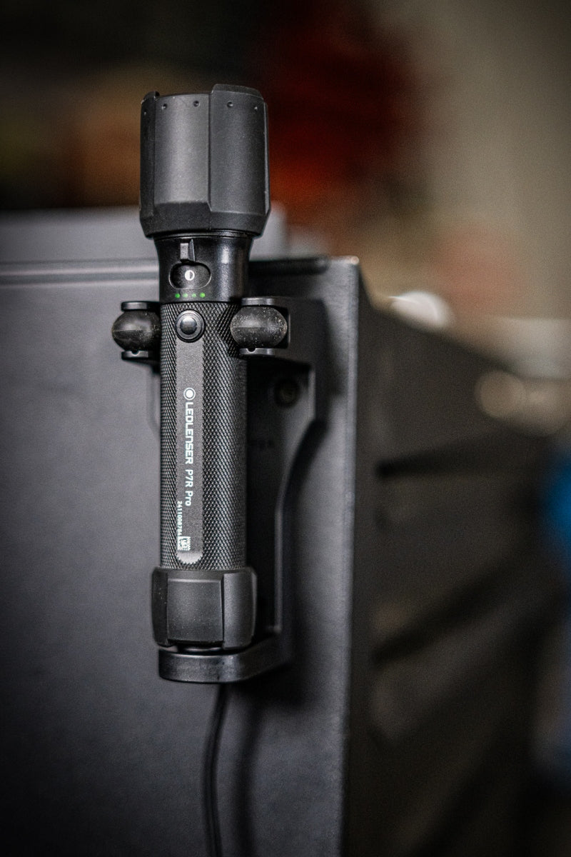Ledlenser P7R Pro Torch mounted in a clamp on a surface with a black textured handle and visible green indicator lights