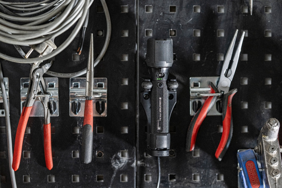 Ledlenser P7R Pro Torch mounted on a pegboard in a workshop with pliers and cables visible