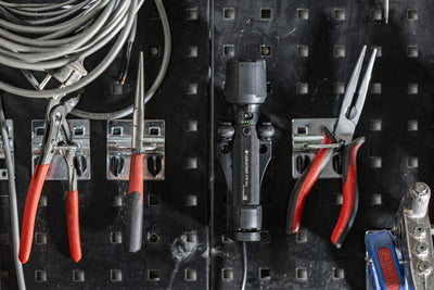 Ledlenser P7R Pro Torch mounted on a pegboard in a workshop with pliers and cables visible