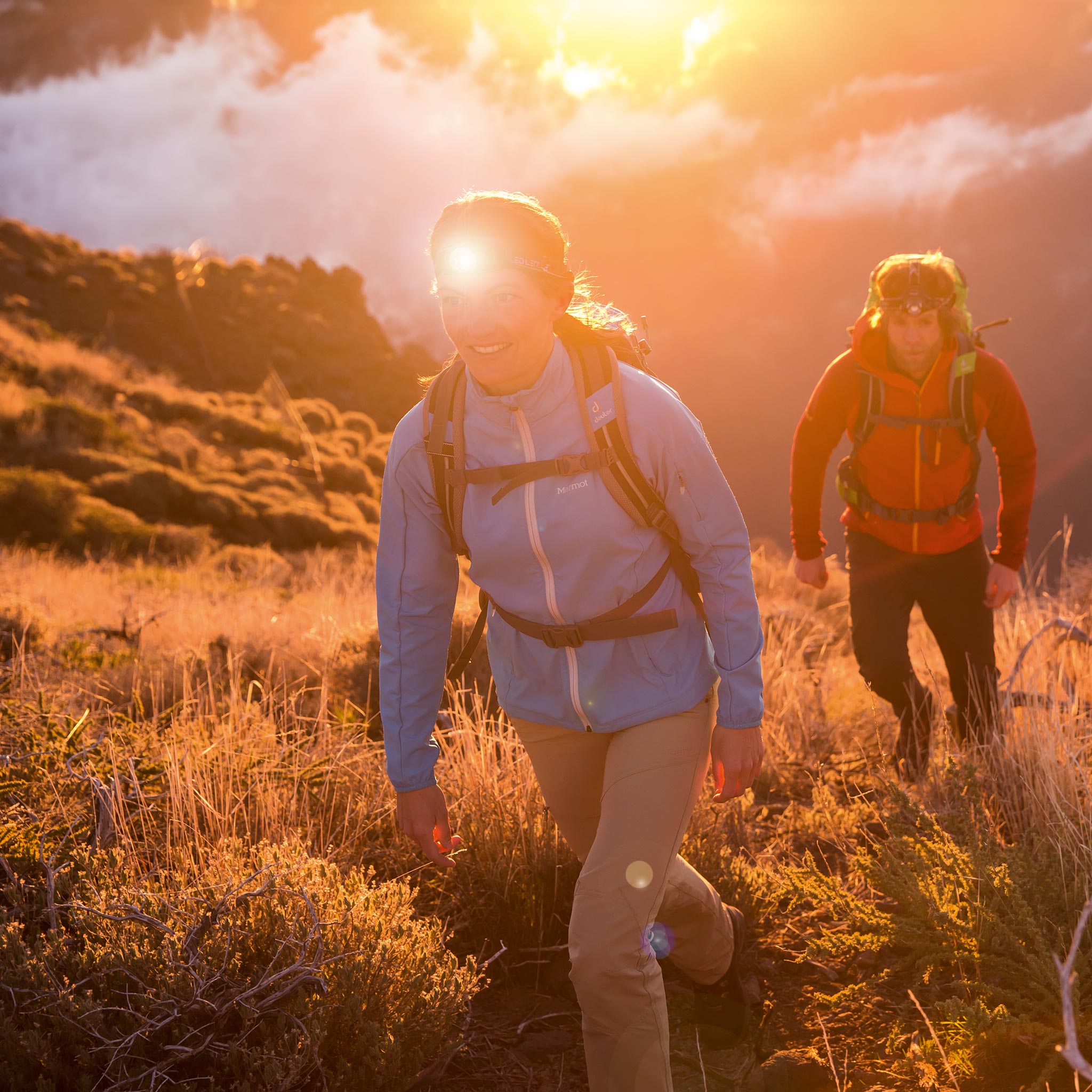 Ledlenser H14R 2 Headlamp worn by a female hiker on a sunset trail with another hiker in the background