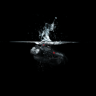 Ledlenser H15R Core Headlamp submerged in water with splash worn on a black headband