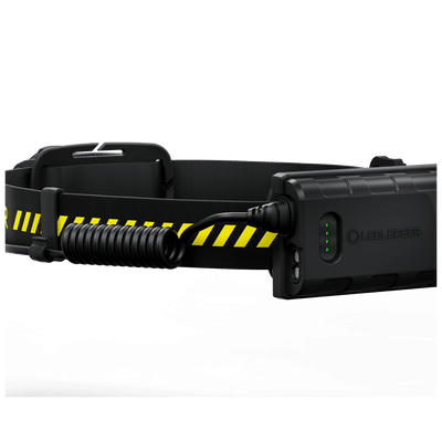 Ledlenser H5R Work Headlamp with black adjustable headband and integrated rechargeable battery pack; coiled charging cable attached to side and front battery housing with green indicator LEDs