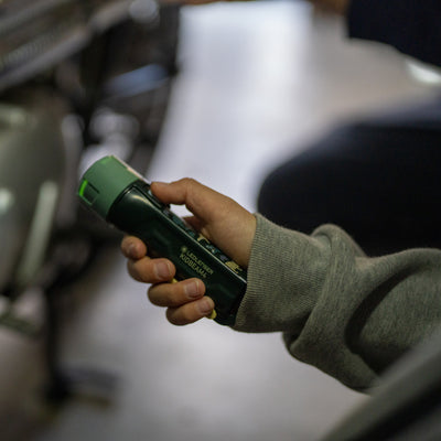 Ledlenser Kidbeam4 torch held in a child’s hand compact green battery operated flashlight with green cap visible