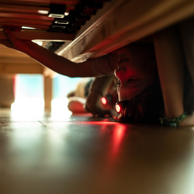 Kidled2 Headlamp worn by child under a table headlamp emitting red light on the floor