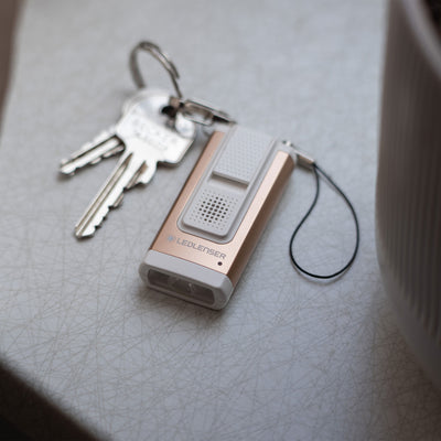 Ledlenser K6R Safety Keychain Light compact rose gold and grey rechargeable keychain torch with metal ring and keys nearby