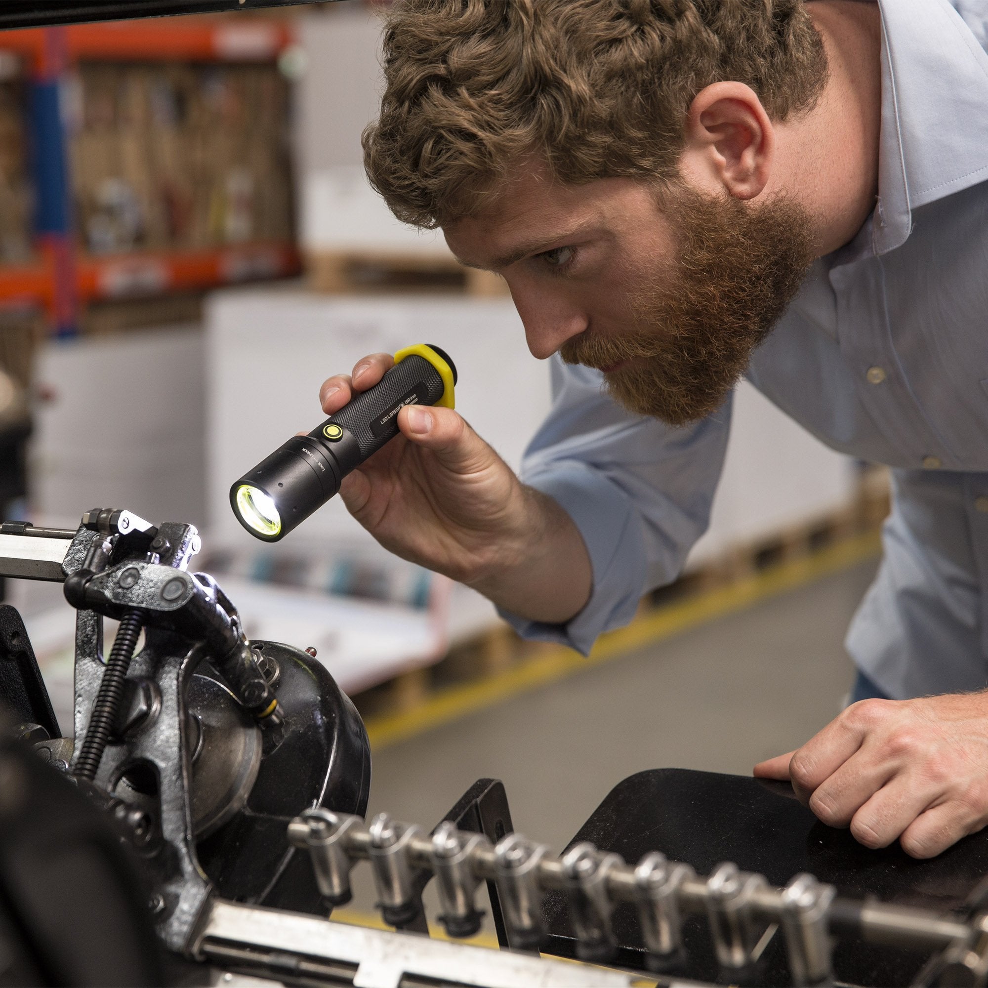 i9R Iron 2 Rechargeable Torch held by a technician inspecting industrial equipment in a workshop