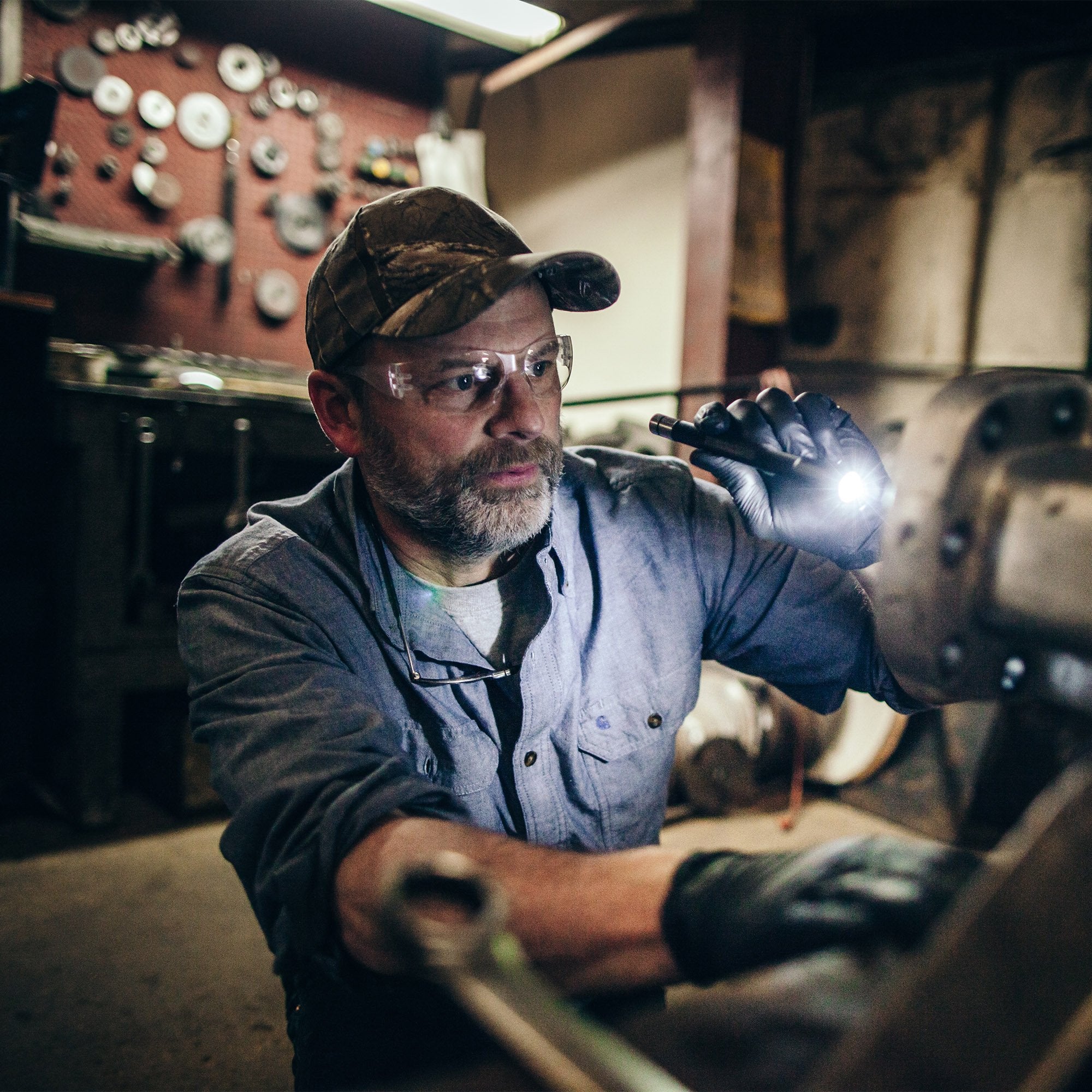 Ledlenser i6R Rechargeable Pen Light in use by a technician in a workshop handheld with a bright beam