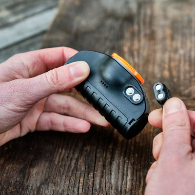 MH11 Outdoor Headlamp by Ledlenser black compact headlamp with orange bezel hands removing the detachable battery module