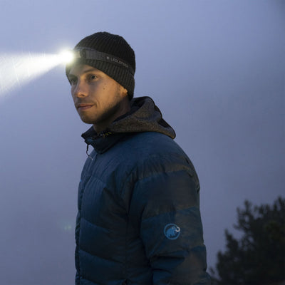 Ledlenser MH3 Headlamp worn by man outdoors at dusk headband with logo bright beam directed to the left