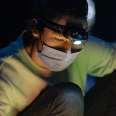 Ledlenser MH7 Powercase Combo headlamp worn by a person at night with the light on and charging case nearby