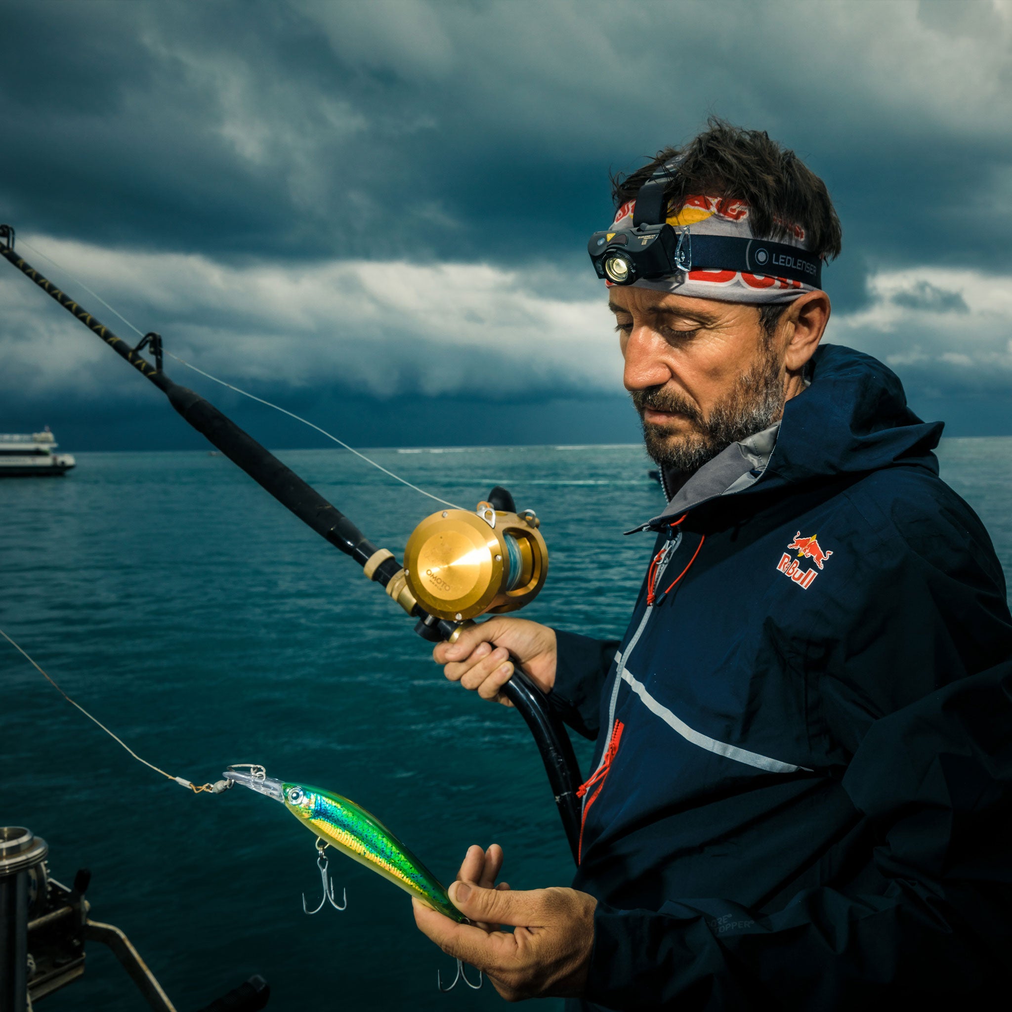 Ledlenser MH8 Outdoor Headlamp worn on a man's head while fishing from a boat under cloudy skies and rough sea