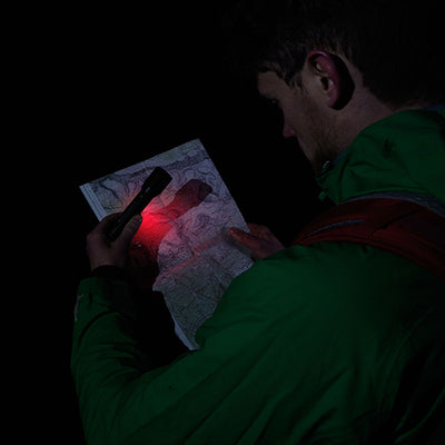 Ledlenser P6R Signature Torch being used to illuminate a map at night person in a green jacket dark background