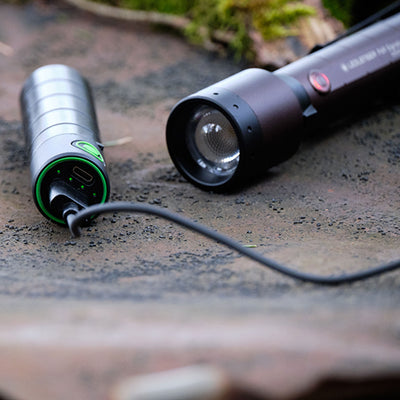 Ledlenser P6R Signature Torch with detachable head and charging tail cap on a rough surface showing green ring USB C port and the lens assembly
