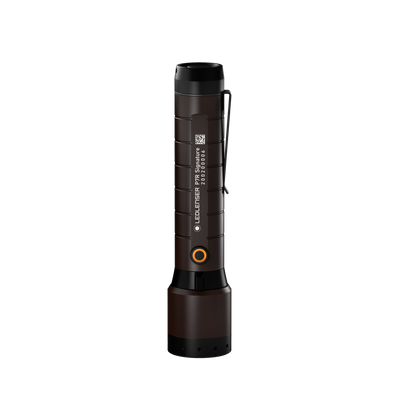 Ledlenser P7R Signature torch standing upright with brown body and orange ring button mounted in a charging cradle