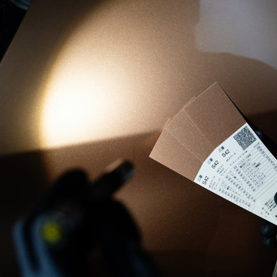 i4 Torch product image showing a hand holding a display card with multiple brown color swatches on a brown surface